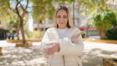 Young woman smiling confident standing with arms crossed gesture at park