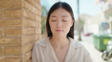 Sokakta kendinden emin gülümseyen Çinli kadın.