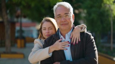 Middle age couple couple smiling confident hugging each other at park