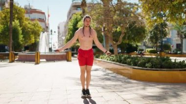 Young man training jump rope exercise at park