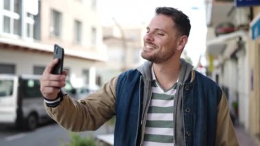 Young caucasian man smiling confident taking selfie picture at street