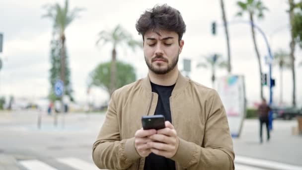 Ung Latinamerikansk Man Använder Smartphone Med Allvarliga Uttryck Gatan — Stockvideo