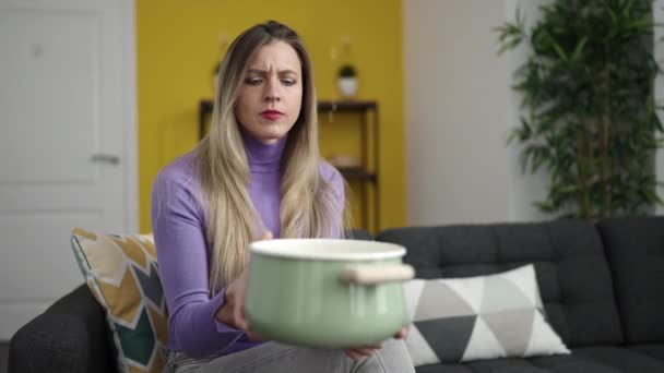 年轻的金发女人拿着锅子在家里放水 — 图库视频影像