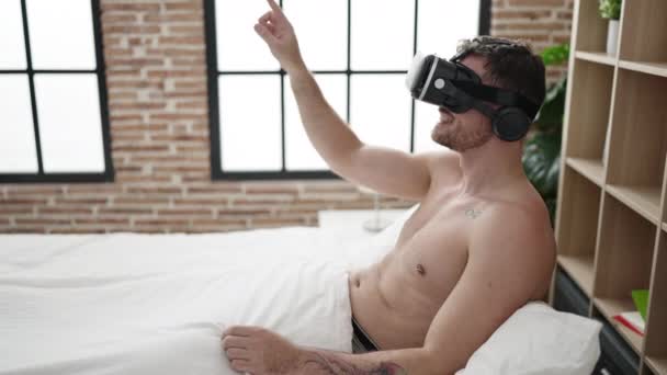 Young Caucasian Man Wearing Virtual Reality Glasses Sitting Bed Bedroom — Stok Video