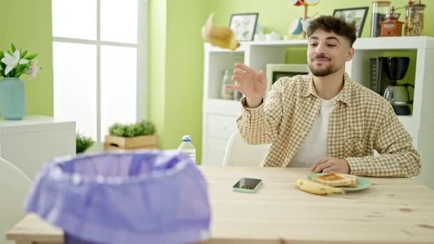 Młody Arabski Człowiek Śniadanie Rzucając Skórką Banana Papierowego Kosza Domu — Wideo stockowe