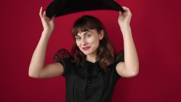 Jonge Kaukasische Vrouw Glimlachend Dragen Heks Kostuum Geïsoleerde Rode Achtergrond — Stockvideo