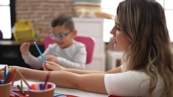 Teacher Boy Girl Sitting Table Drawing Paper Kindergarten — Vídeo de stock