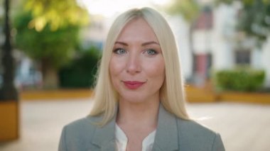 Young blonde woman executive smiling confident standing at park