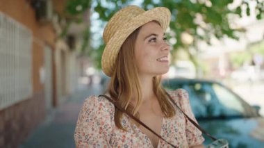 Young woman tourist wearing summer using vintage camera at street