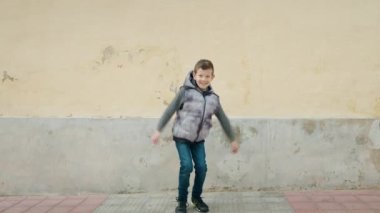 Blond child smiling confident jumping at street