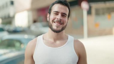 Sokakta kendinden emin gülümseyen İspanyol genç adam.