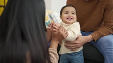 Çift ve oğul evde birlikte otururken kendinden emin bir şekilde gülümsüyor.