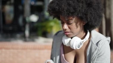 African american woman sitting on bench for injury knee at park