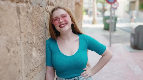 Joven Pelirroja Sonriendo Confiada Usando Gafas Sol Corazón Calle — Vídeo de stock