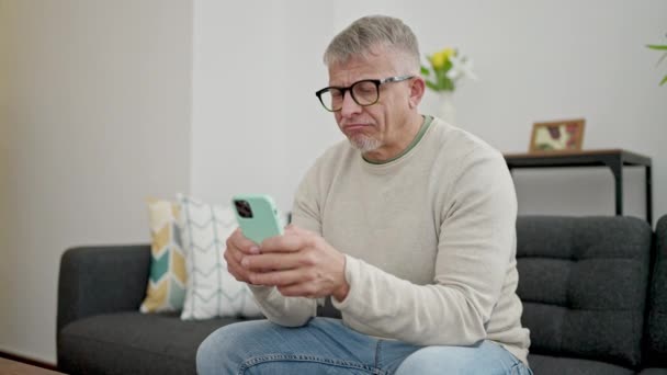 Μέση Ηλικία Γκριζομάλλης Άνθρωπος Χρησιμοποιώντας Smartphone Κάνει Χειρονομία Στο Σπίτι — Αρχείο Βίντεο