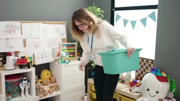 Young Blonde Woman Preschool Teacher Picking Toys Kindergarten — ストック動画