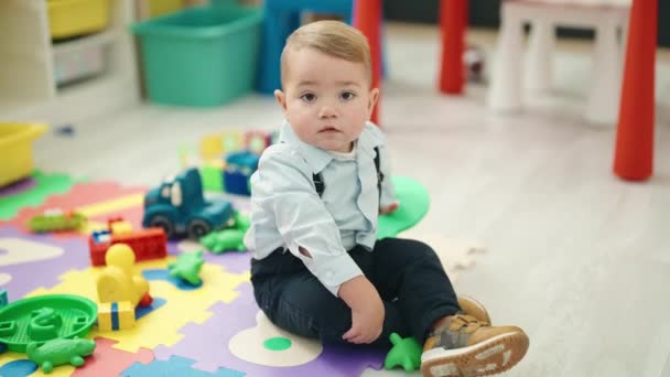 Liebenswertes Blondes Kleinkind Sitzt Kindergarten Auf Dem Fußboden Mit Der — Stockvideo