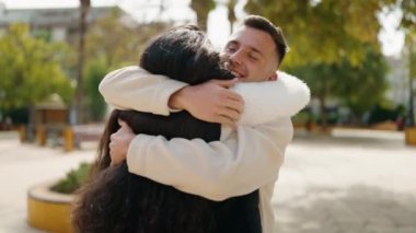 Young couple smiling confident hugging each other standing at park