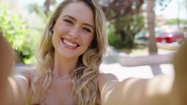 Young blonde woman smiling confident making selfie by camera at park