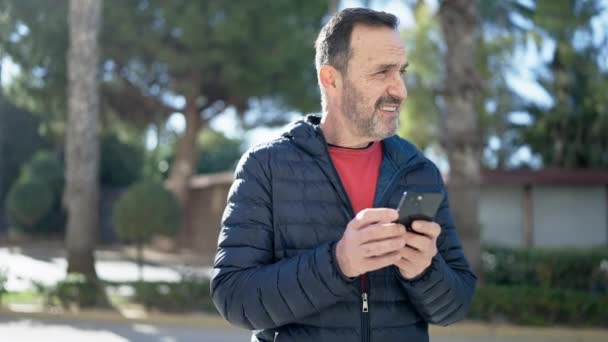 Uomo Mezza Età Sorridente Fiducioso Utilizzando Smartphone Parco — Video Stock