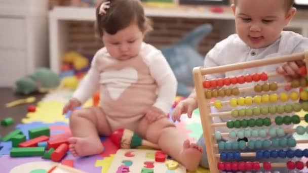 幼稚園の床に座っているそろばんで遊んでいる2人の幼児 — ストック動画