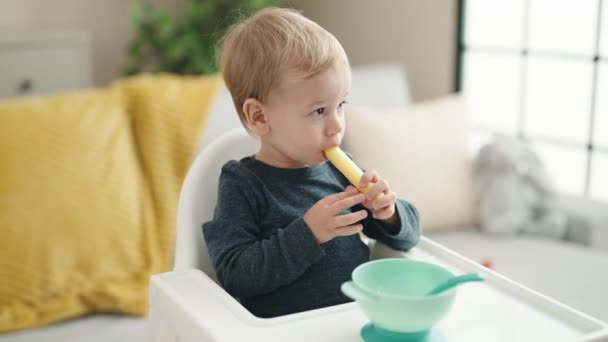 Adorável Loira Criança Sentada Cadeira Alta Comer Lanche Casa — Vídeo de Stock