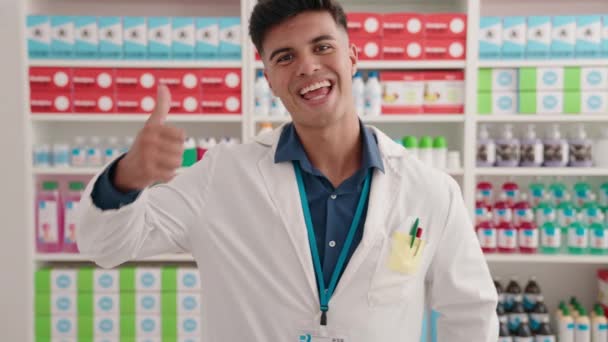 Young Hispanic Man Pharmacist Smiling Confident Doing Gesture Thumbs Pharmacy — Video