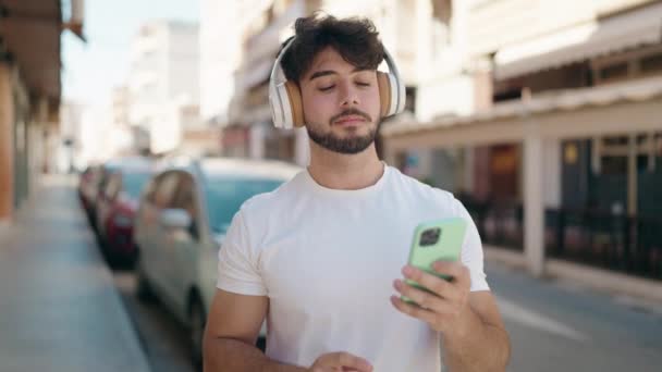 Jeune Homme Hispanique Souriant Confiant Écoutant Musique Dans Rue — Video