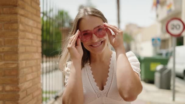 Joven Mujer Caucásica Sonriendo Confiada Usando Gafas Sol Corazón Calle — Vídeo de stock