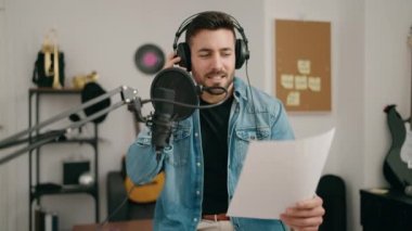 Genç İspanyol adam müzik stüdyosunda şarkı söylüyor.