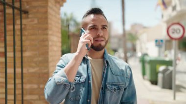 Genç İspanyol adam akıllı telefondan konuşuyor. Sokakta nöbet tutuyor.