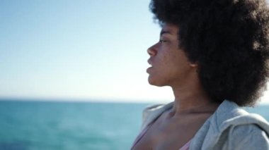 Afrika kökenli Amerikalı kadın deniz kenarında dua ediyor.