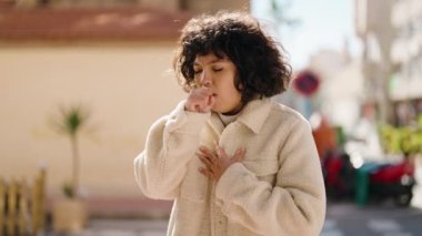 Young hispanic woman coughing at street