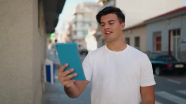 Latin asıllı genç adam gülümsüyor.