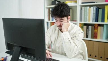 Genç İspanyol öğrenci kütüphane üniversitesinde bilgisayar kullanmaktan yoruldu.