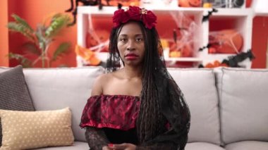 African woman wearing katrina costume at home
