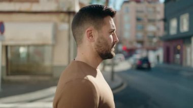 Sokakta kendinden emin gülümseyen İspanyol genç adam.