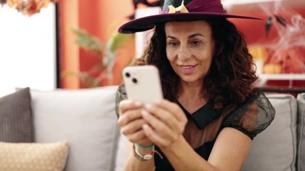 Middle Age Hispanic Woman Using Smartphone Having Halloween Party Home — Vídeos de Stock