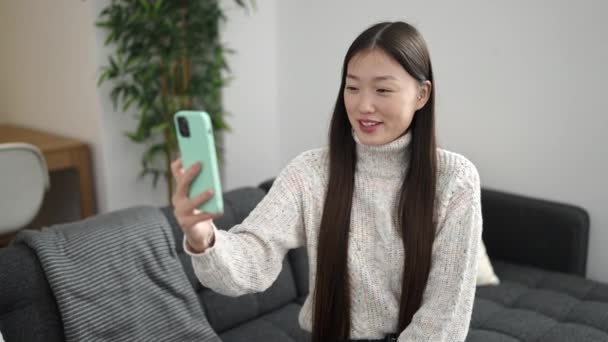 Ung Kinesisk Kvinna Som Har Videosamtal Sitter Soffan Hemma — Stockvideo