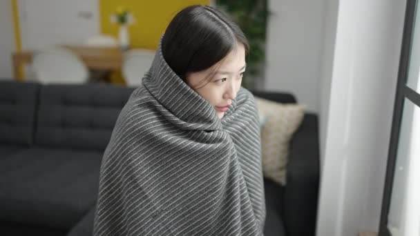 Soğuk Battaniyeyle Örtülü Genç Çinli Kadın Evdeki Kanepede Oturuyor — Stok video