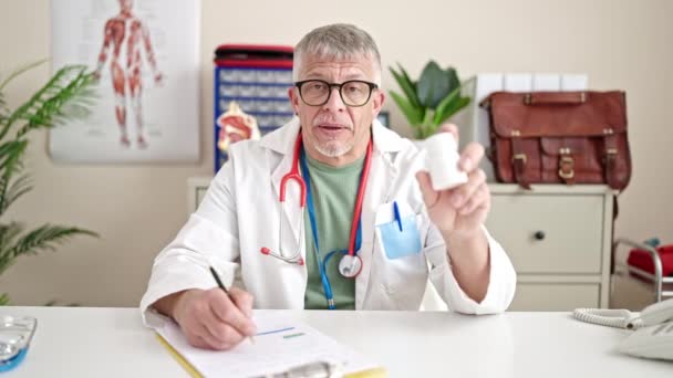 Medelålders Gråhårig Man Läkare Ordinerar Piller Kliniken — Stockvideo