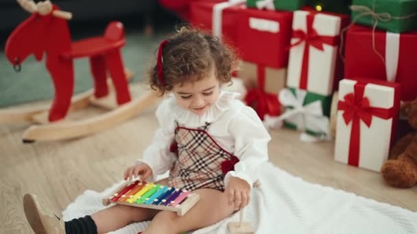Adorable Hispanic Girl Playing Xylophone Sitting Floor Christmas Tree Home — Vídeo de stock