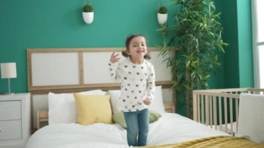 Anaokulunda yatağa atlarken kendine güvenen sevimli bir kız.
