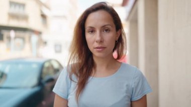 Sokakta kendinden emin gülümseyen genç bir kadın