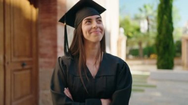 Üniversitede kollarını kavuşturmuş duran, üniformalı İspanyol bir kadın.