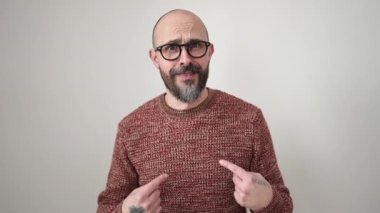 Genç, kel bir adam, izole edilmiş beyaz arka planda parmağını hareket ettirmiyor.