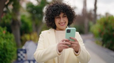 Young woman smiling confident making selfie by the smartphone at park