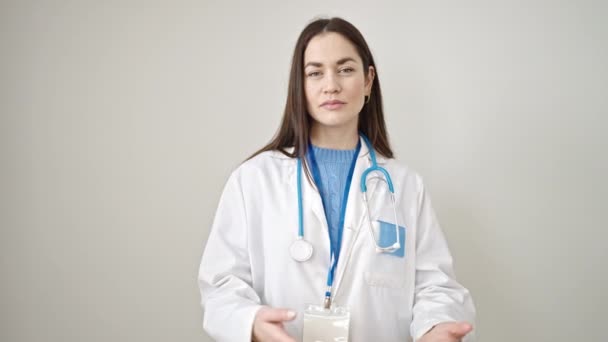Junge Kaukasische Ärztin Lächelt Selbstbewusst Und Präsentiert Vor Isoliertem Weißen — Stockvideo