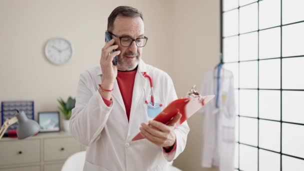 Mann Mittleren Alters Spricht Auf Smartphone Und Liest Arztbericht Klinik — Stockvideo