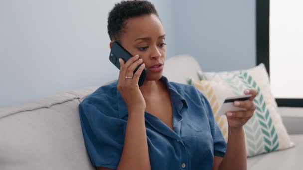Afroamerikanerin Spricht Auf Smartphone Und Hält Kreditkarte Hause Auf Sofa — Stockvideo